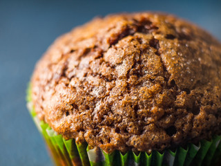 Banana chocolate muffins with caramel sugar topping on dark background