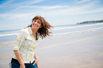 Happy midle aged woman on the beach