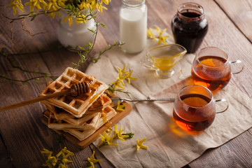 Fototapeta na wymiar Waffles, tea, honey and milk on a neutral background