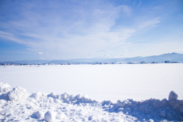 Fototapeta na wymiar 雪原から見える山と街1