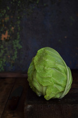 Young spring white cabbage on a dark wooden background. Raw Food