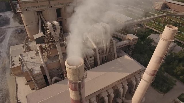 Large industrial concrete cement building plant Russia Spassk-Dalny regional center. Primorsky krai. Close smoke tube pipe pollution. Nature Aerial drone 4k footage. Summer day