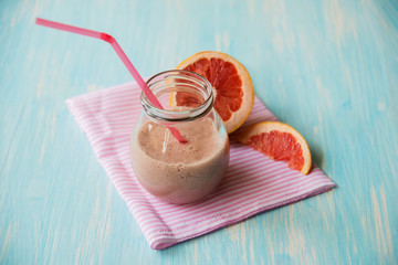 Grapefruit smoothie with ginger root and honey in a glass jar