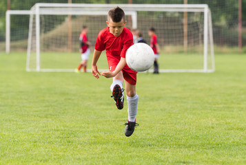 Obraz premium Kids soccer football - children players match on soccer field