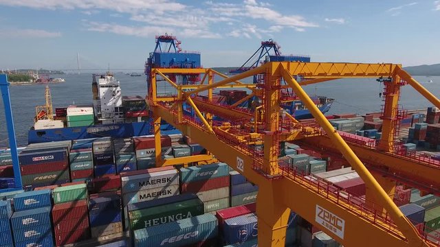 Free port zone Vladivostok Russia Local industrial containers cranes transport. Golden horn Russky bridge rail journey steel constructions Port unloading Freight. Summer. Unique Aerial flight close to