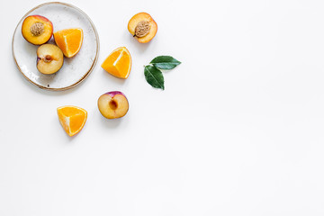 tropical peach and orange fruits for fresh juice on plates white background top view space for text