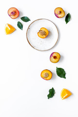 tropical fruits design with orange and peach on plate white background top view mock up