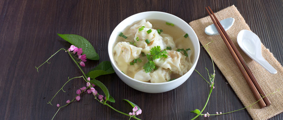 Shrimp wonton with braised pork in soup on wooden table / Select focus image..