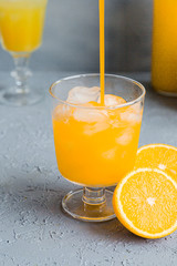Fresh Orange Juice in Glass and Bottles and some Ripe Oranges on Grey Background. Healthy Drink, diet or Detox. © shutnica