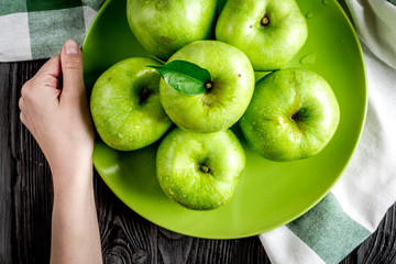 ripe green apples in plate dark wooden table background top view space for text