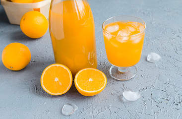 Fresh Orange Juice in Glass and Bottles and some Ripe Oranges on Grey Background. Healthy Drink, diet or Detox. © shutnica