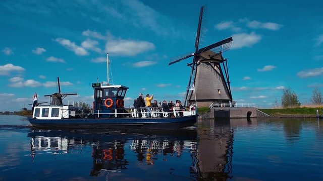 Traditional Dutch windmills from the channel Rotterdam. Water mirror effect. Holland. Right side turning camera.
