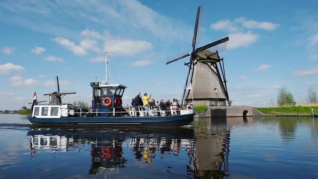 Traditional Dutch windmills from the channel Rotterdam. Water mirror effect. Holland. Right side turning camera.