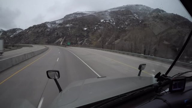 Forward Facing Dashcam-style footage from the interior of a Semi Truck traveling down a rural US Highway. 