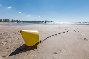 Bouée conique jaune sur la plage à marée basse