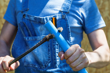 worker with wrench in hand holds plastic pipe