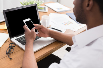 African-american businessman in office type on laptop