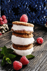 Homemade ice cream sandwiches  with  raspberries and mint on old black wooden over  texture background.