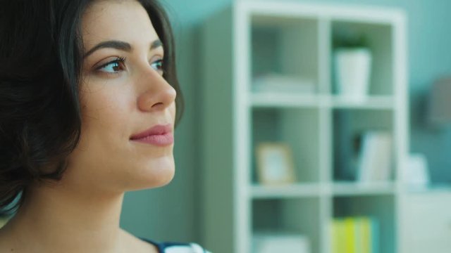 Close up woman portrait. Beautiful young woman turning head to camera and smiling. Indoors