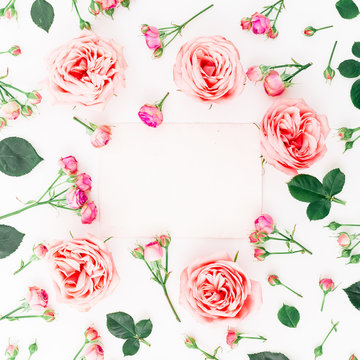 Floral frame of pink roses, buds and card on white background. Flat lay, top view. Floral background.