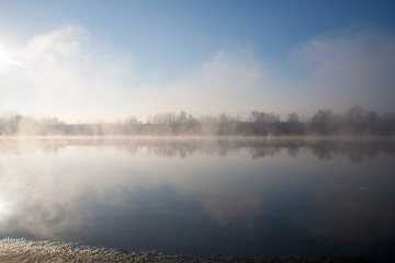 Fototapeta na wymiar A misty dawn on the river in the early morning in the village