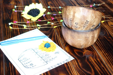 Two ceramic pottery handmade bowl and card drawing in sketching and doodling style with blue pen and spring sprig on wooden background