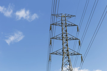 High voltage power pole with blue sky background