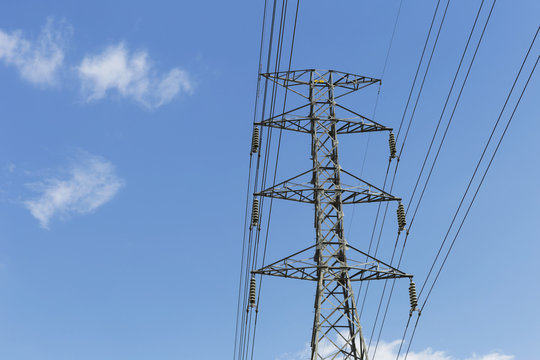 High voltage power pole with blue sky background