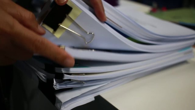 Businessman choose in Stack of paperwork files on work desk in office