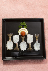 Butterfly shrimps with lemon and tomato on black plate with pink background
