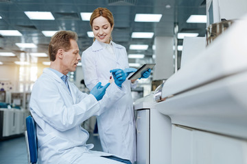 Attractive young colleague standing near her professor