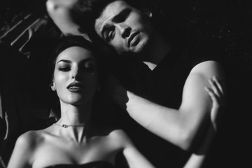 Naklejka premium stylish couple lying on the ground and smiling