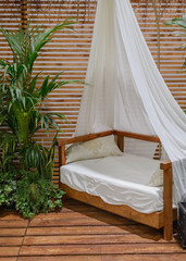 four-poster bed on a wooden porch