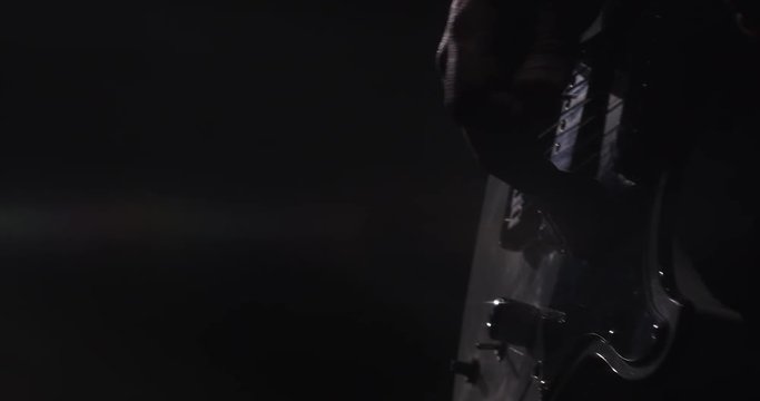 Close up of a man playing a guitar during a live performance. 