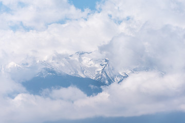 Fototapeta na wymiar Ghostly mountain peak showing from a cloudy veil