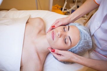 doctor cosmetologist doing facial massage girl spa