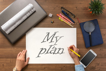Girl draw question mark on paper sheet  at the table with a mobile phone, a laptop, business...