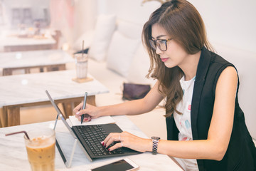 Businesswoman working on desk with laptop computer,Businesswoman using pen for note to do list concept.