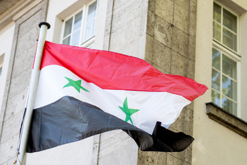 Syrian flag waving. Horizontal tricolour of red, white, and black with two green stars at the...