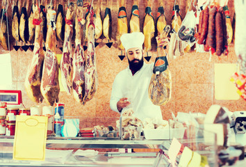 Man seller showing jamon