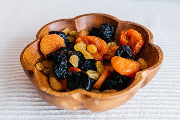 vegan snack with dry apricots, plums, and raisins, selective focus