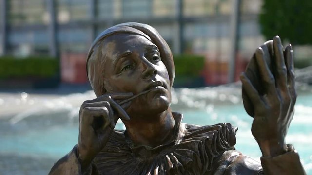 A woman bronze statue with a mirror in the hand in a square in Bratislava