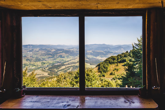 Fototapeta Summer field and mountains seen through the window