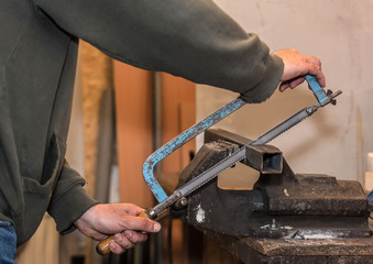 Engineer working on cutting a metal with saw