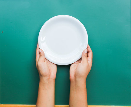 Hand Holding A Plate On The Table