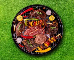 Foto op Plexiglas Bovenaanzicht van vers vlees en groente op de grill geplaatst op gras © Jag_cz