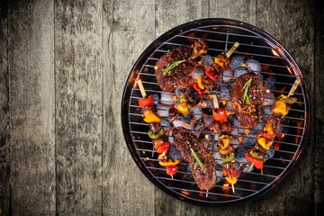 Foto op Canvas Bovenaanzicht van vers vlees en groente op grill geplaatst op houten vloer © Jag_cz