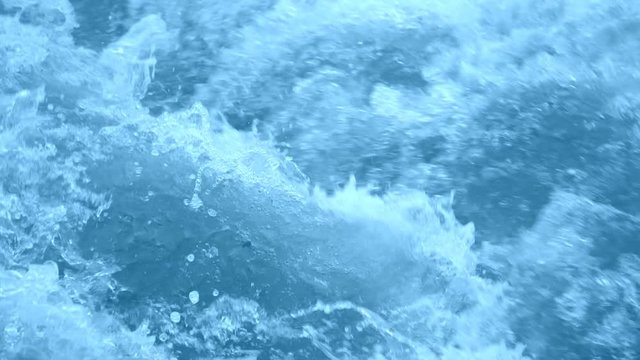 A powerful stream of bubbling blue water. Slow Motion 180 fps