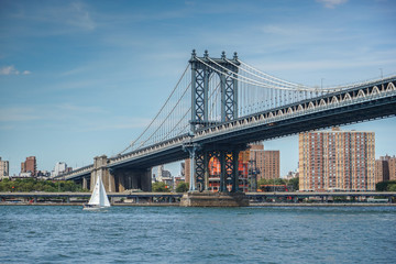 Fototapeta na wymiar Manhattan Bridge with a sailboat