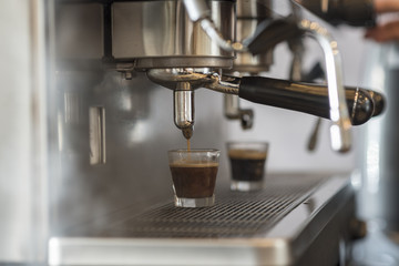Prepares espresso in his coffee shop; close-up